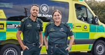 Two Hato Hone St John ambulance officers standing in front of their ambulance.